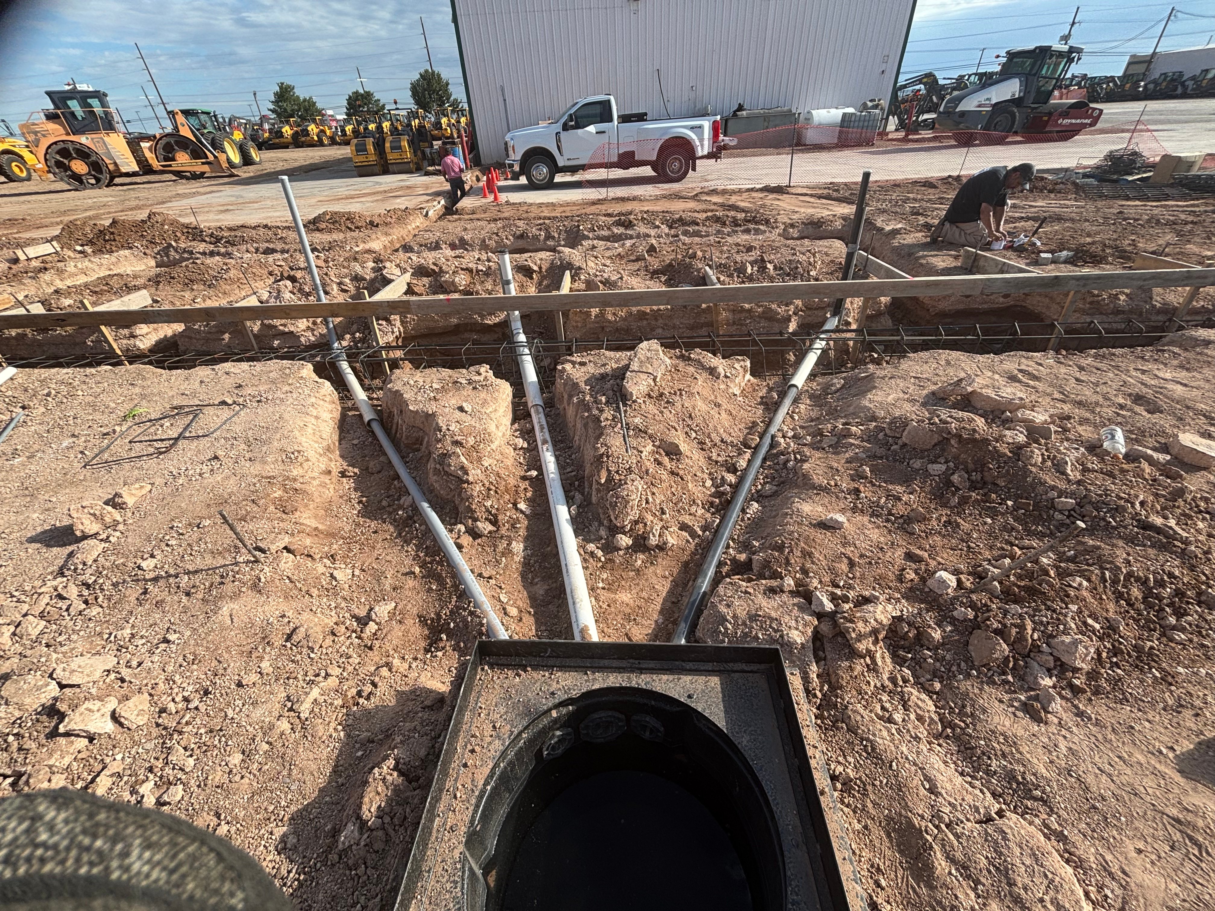 Underground plumbing pipes installed in excavated trenches with metal bracing and support structures