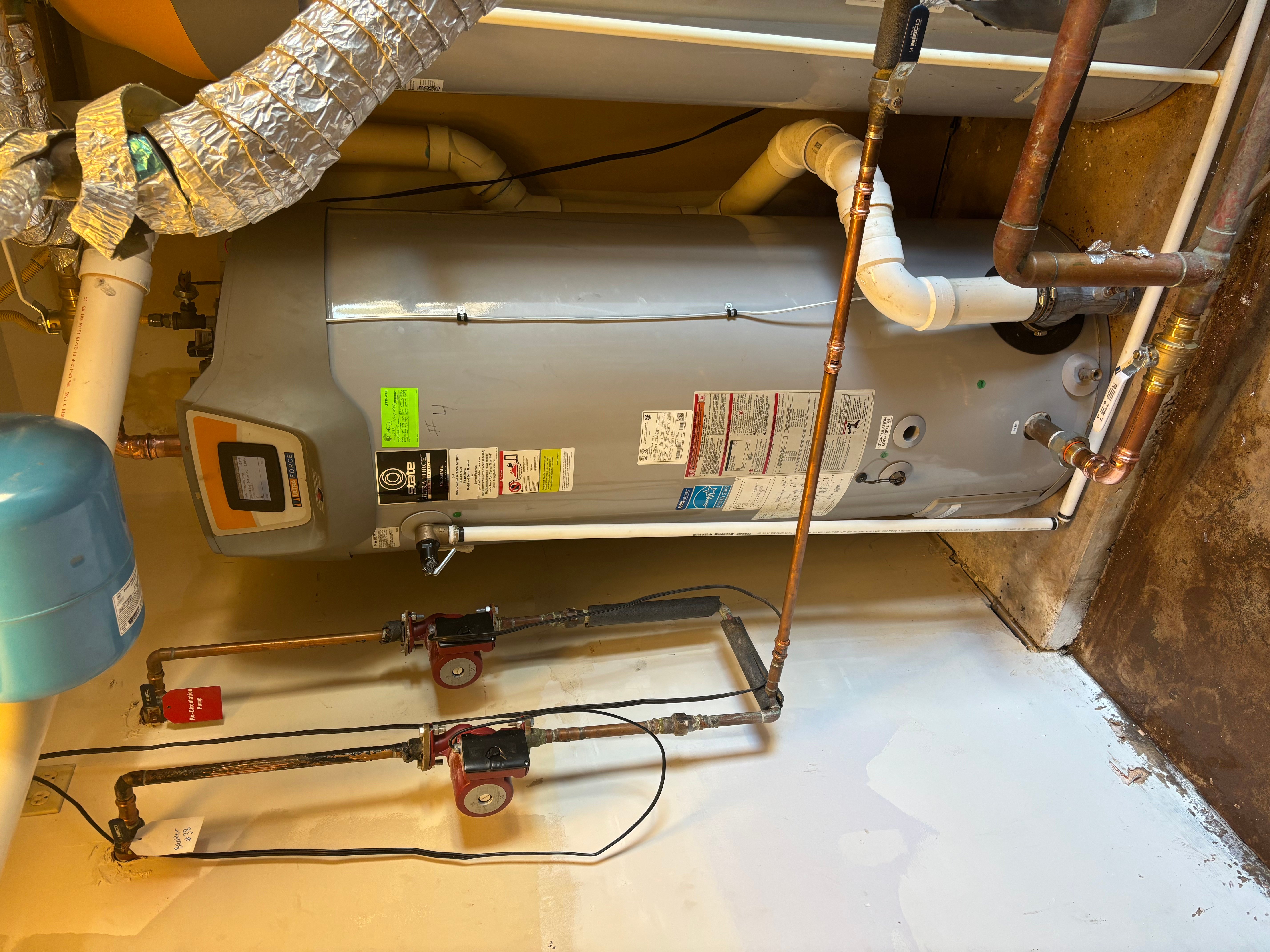 Installed water heater with copper piping, shut-off valves, and insulated ductwork in utility space